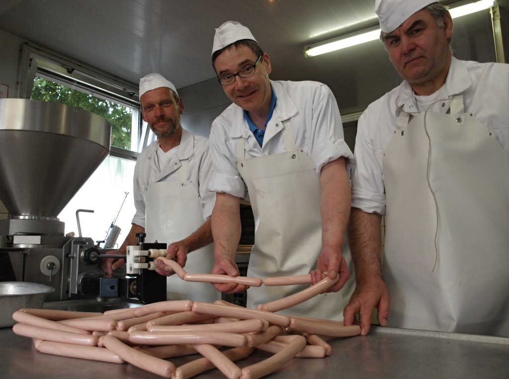 Erklären die Grillsaison für eröffnet: Fleischermeister Stefan Loske (Mitte) und seine Mitarbeiter Heiner Michel und Waldemar Gersch bei der Produktion ihrer hausgemachten Bratwürste. Foto: Ulrike Havermeyer