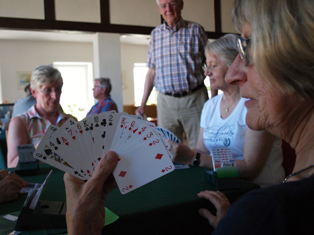 Bridge ist wie Schach mit Karten: Georg Meyer (im Hintergrund) schaut interessiert zu, was Ingeborg und Bärbel, Helga und Gretel aus ihren jeweils 13 Karten machen.